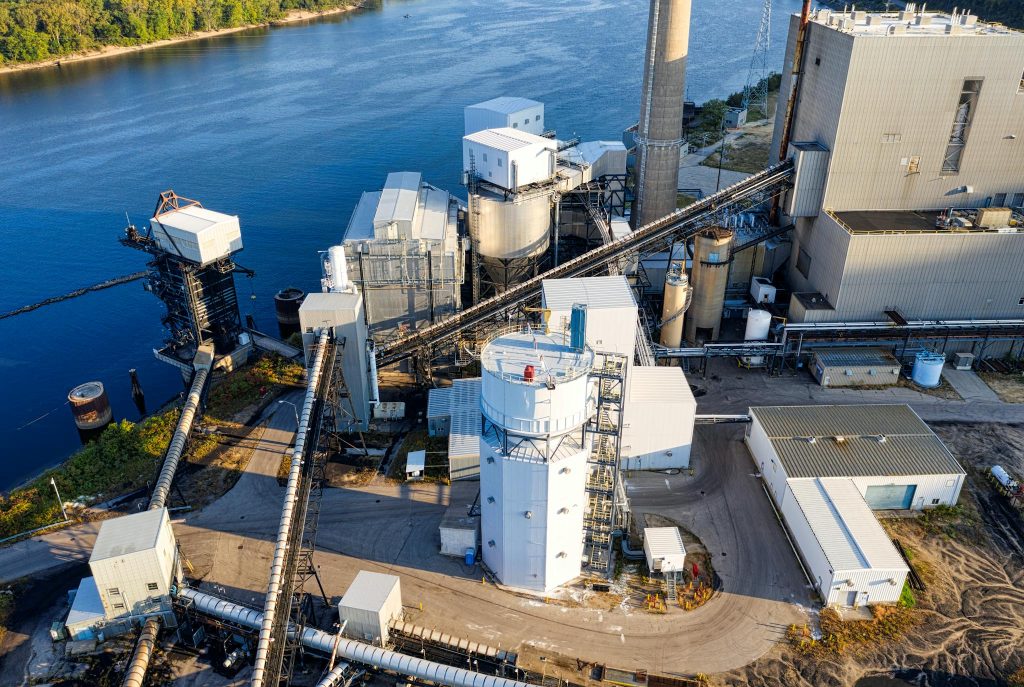 Aerial view of a power plant in Genoa, Wisconsin by the riverside.